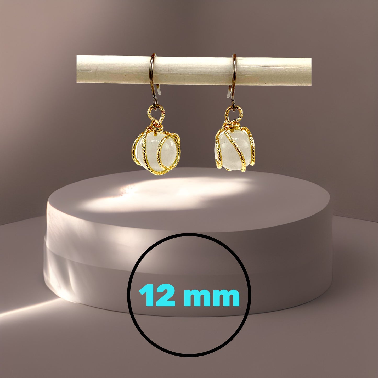 Gold caged pearl earrings 12 mm and a titanium hook on a beige background