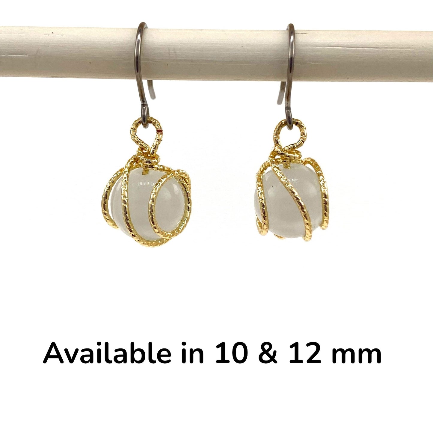 Gold caged pearl earring a titanium hook on a white backgroundearrings on a white background with text indicating size options.