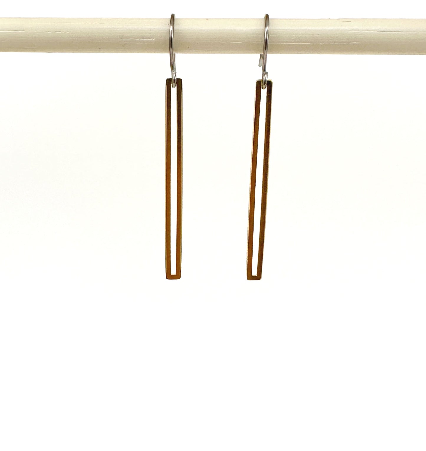 Gold narrow rectangular loop earring with a titanium hook on a white background
