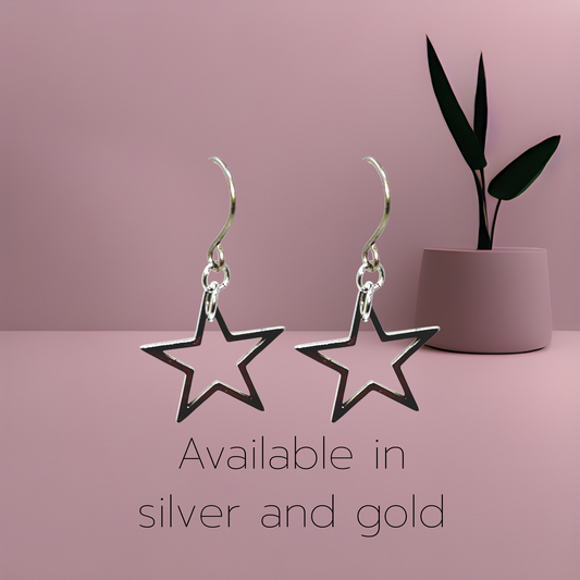 Silver and gold Star Titanium Earrings with a titanium hook on a pink background