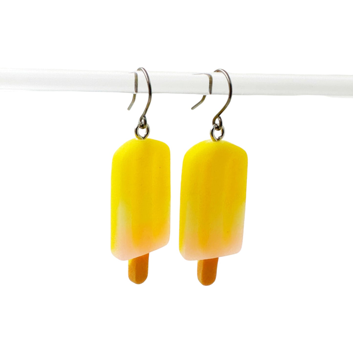 Popsicle earrings with a titanium hook on a white background. yellow