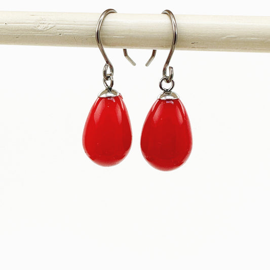 Red pearl earrings with a titanium hook on a white background