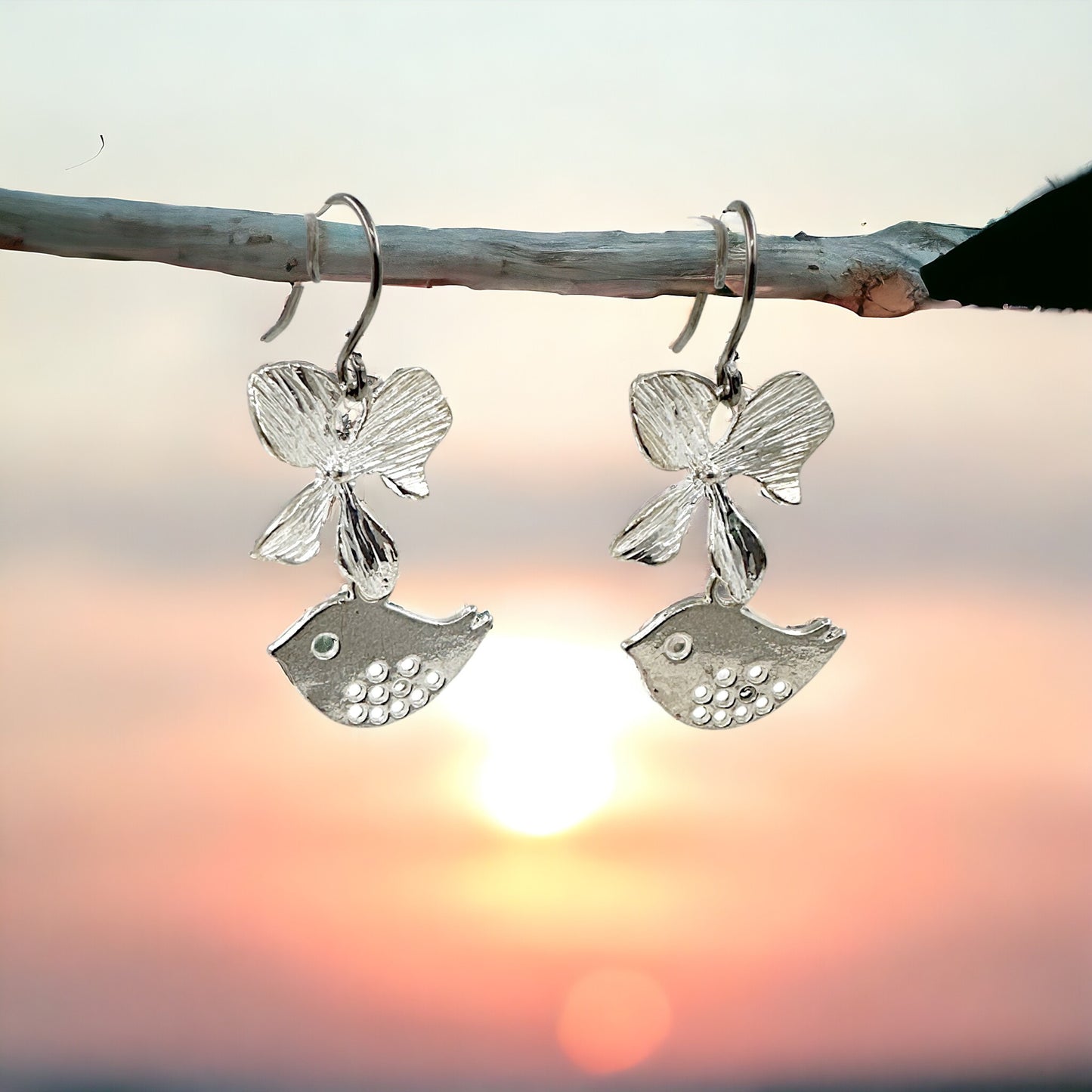 Songbird Charm earrings with a titanium hook on a sky background
