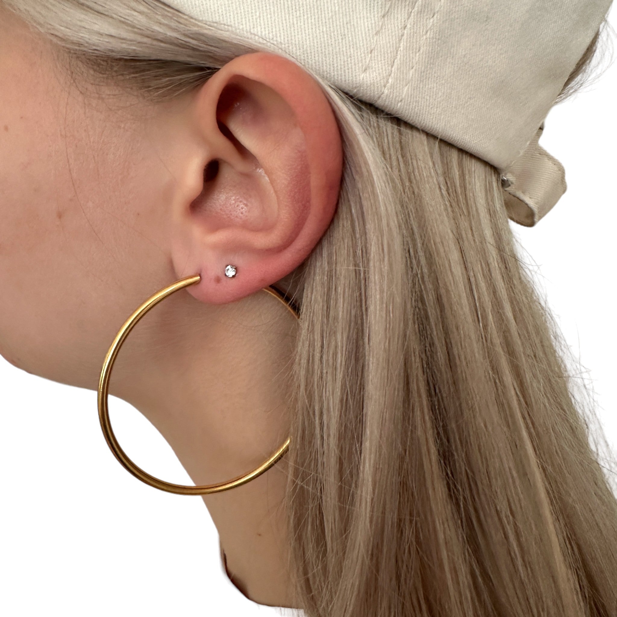 Hoops on a white woman with blond hair made from titanium. Gold large titanium earring pair durable.