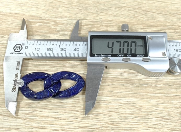 Burgandy Chain Studs with titanium posts being measured with a vernier