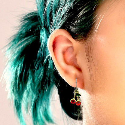 Cherry gem earrings with a titanium hook on a white young woman.