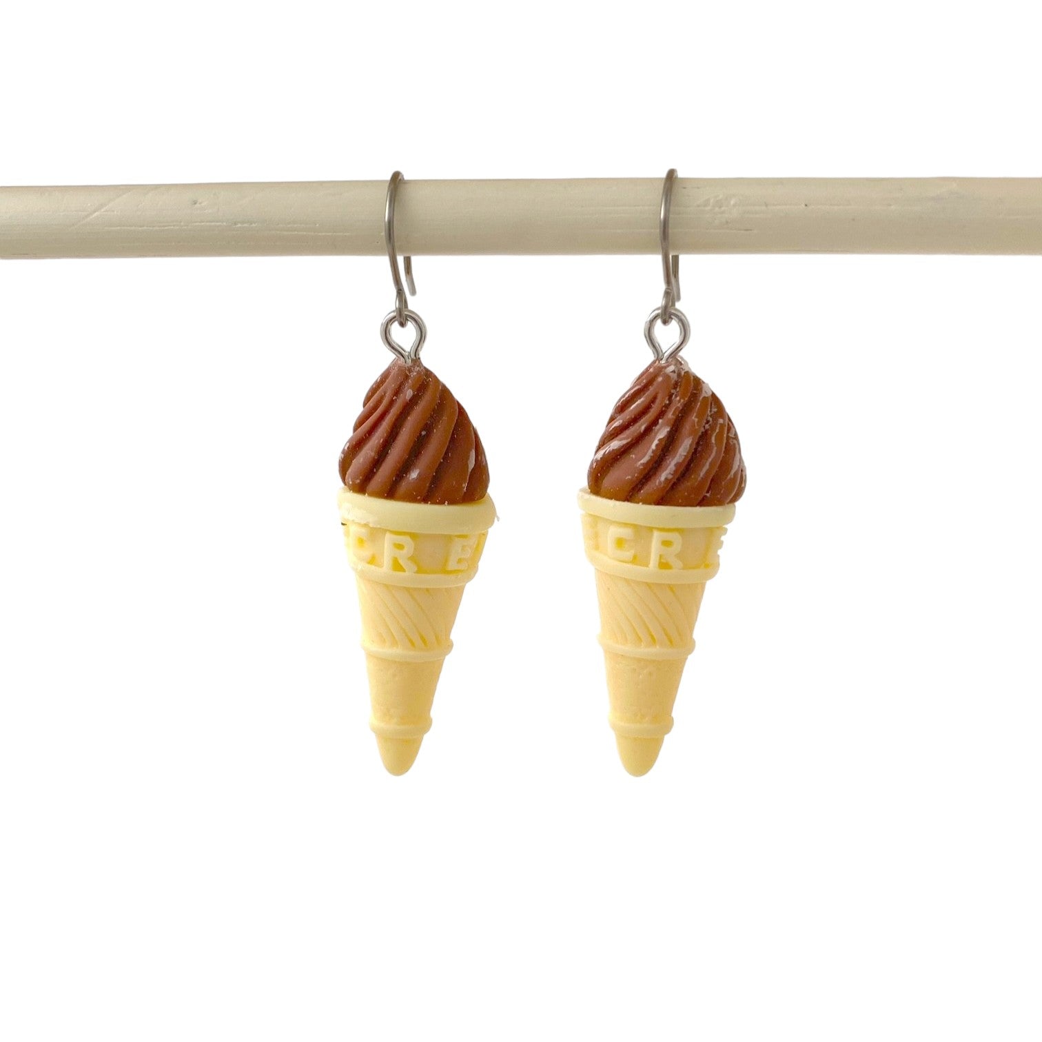 Ice cream earrings with a titanium hook . brown . on a white background