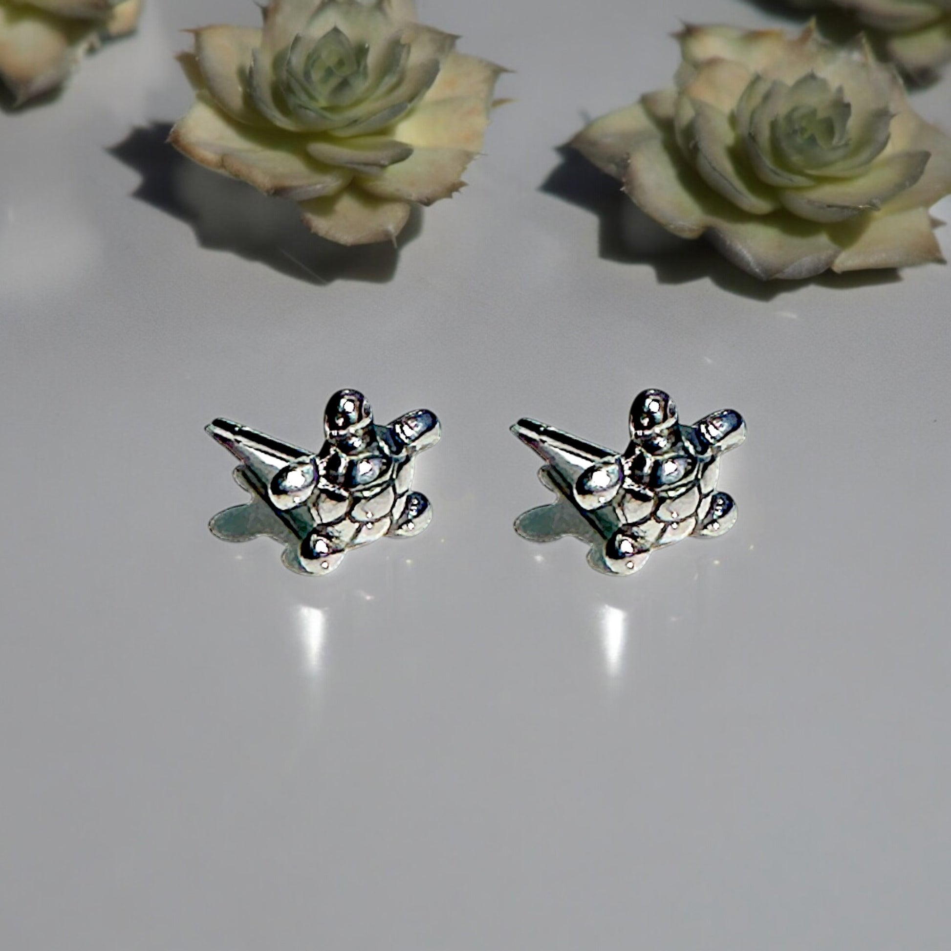 Turtle Studs -solid titanium studs and backs- Feature a small and minimal design on a white grey background