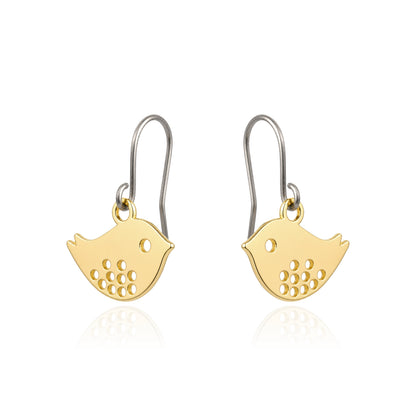 A pair of gold bird-shaped titanium drop earrings on a white background with a soft reflection below.