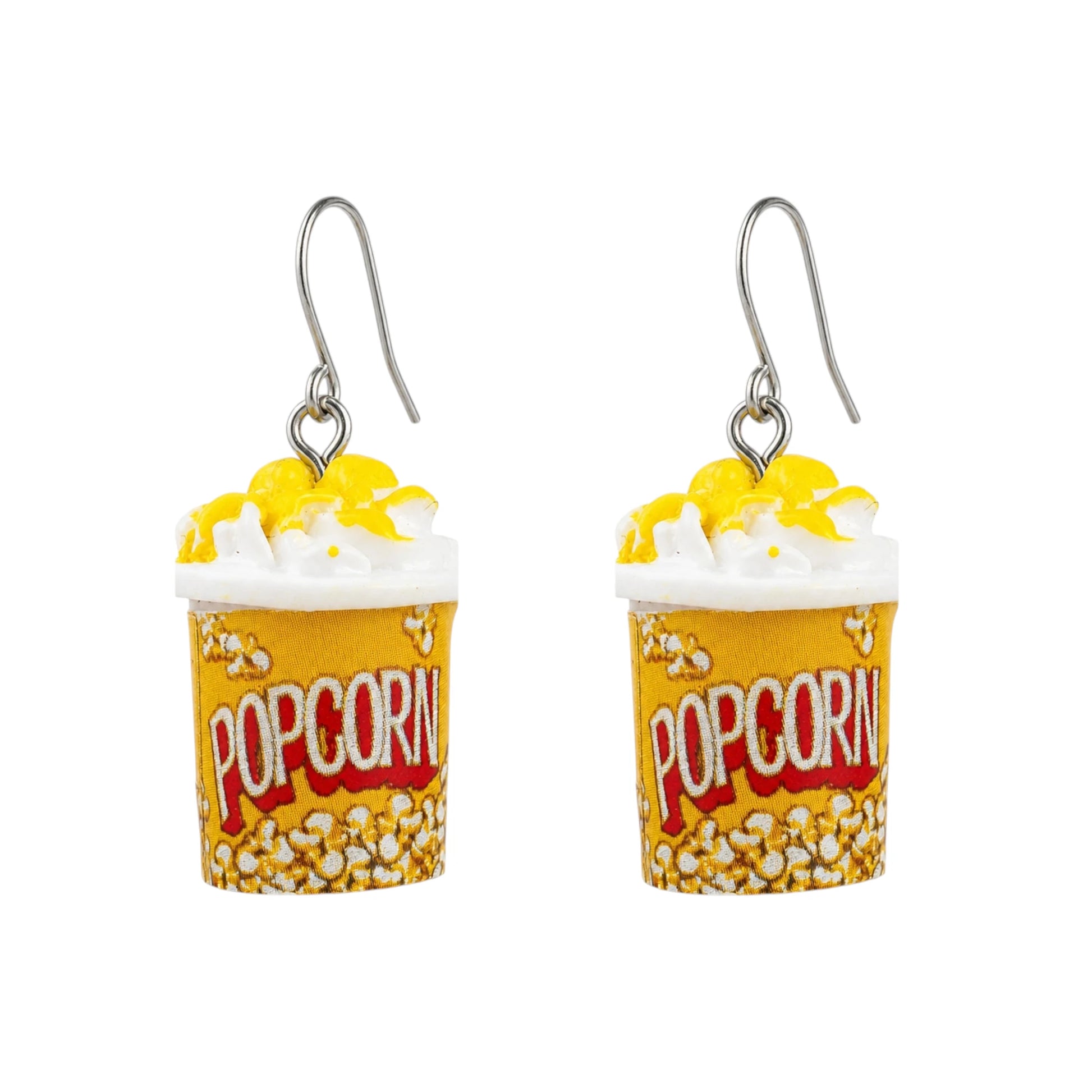 A pair of novelty popcorn bucket earrings with yellow and white popcorn, white whipped cream, and a titanium fishhook ear wire, displayed on a clean white background with a subtle reflection.