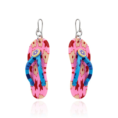 A pair of titanium dangling flip-flop-shaped earring. The earring has a pink and orange floral upper with blue straps