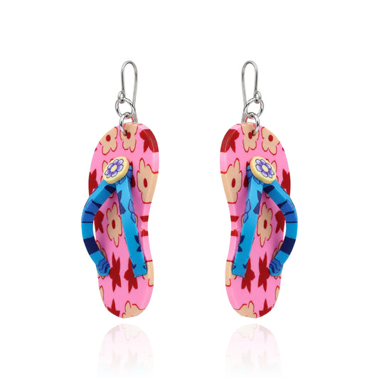 A pair of titanium dangling flip-flop-shaped earring. The earring has a pink and orange floral upper with blue straps