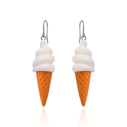 A pair of dangling earrings shaped like ice cream cones, with white swirls representing soft serve and an orange waffle-cone base, hanging from titanium fishhook ear wires on a white background.