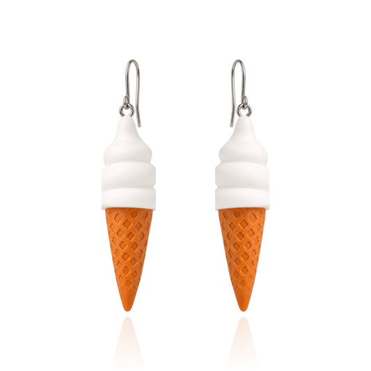 A pair of dangling earrings shaped like ice cream cones, with white swirls representing soft serve and an orange waffle-cone base, hanging from titanium fishhook ear wires on a white background.
