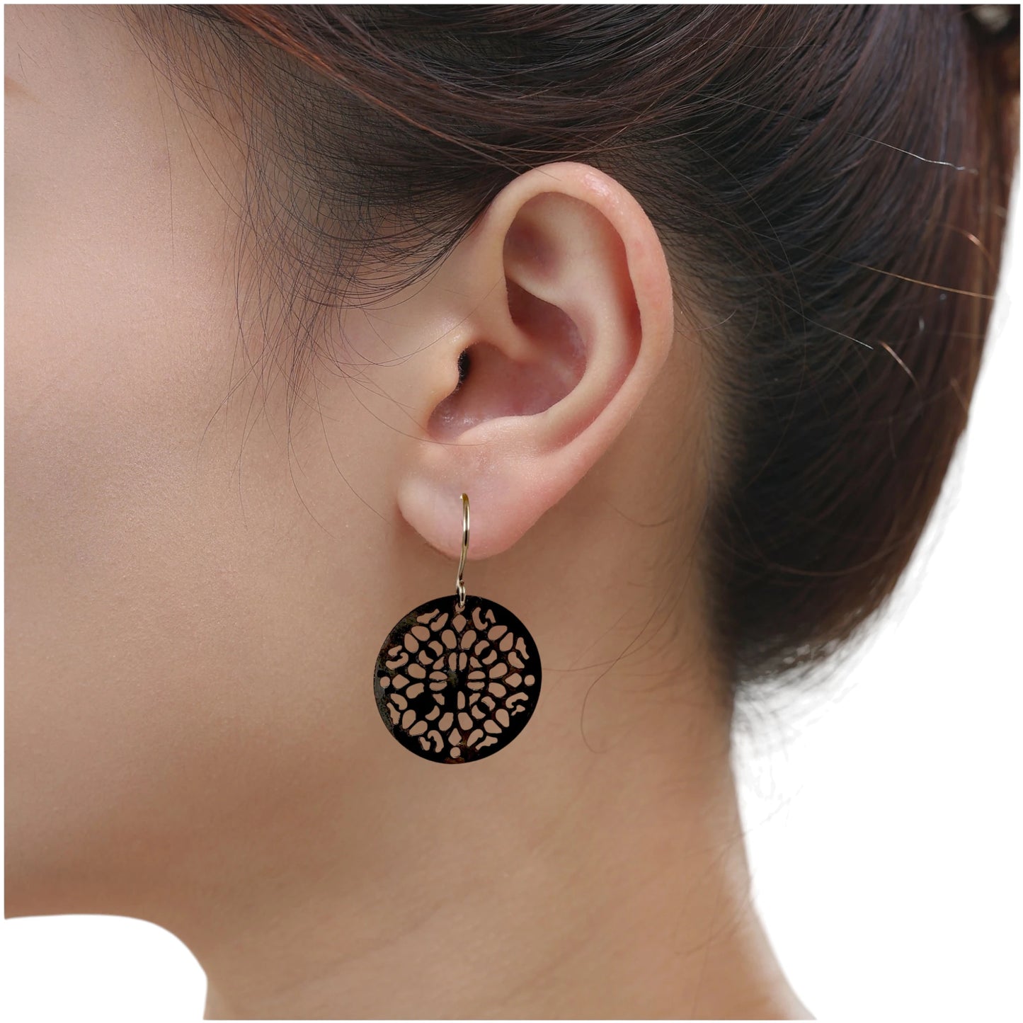 Black geometric disc earrings with a titanium hook on a white young woman.