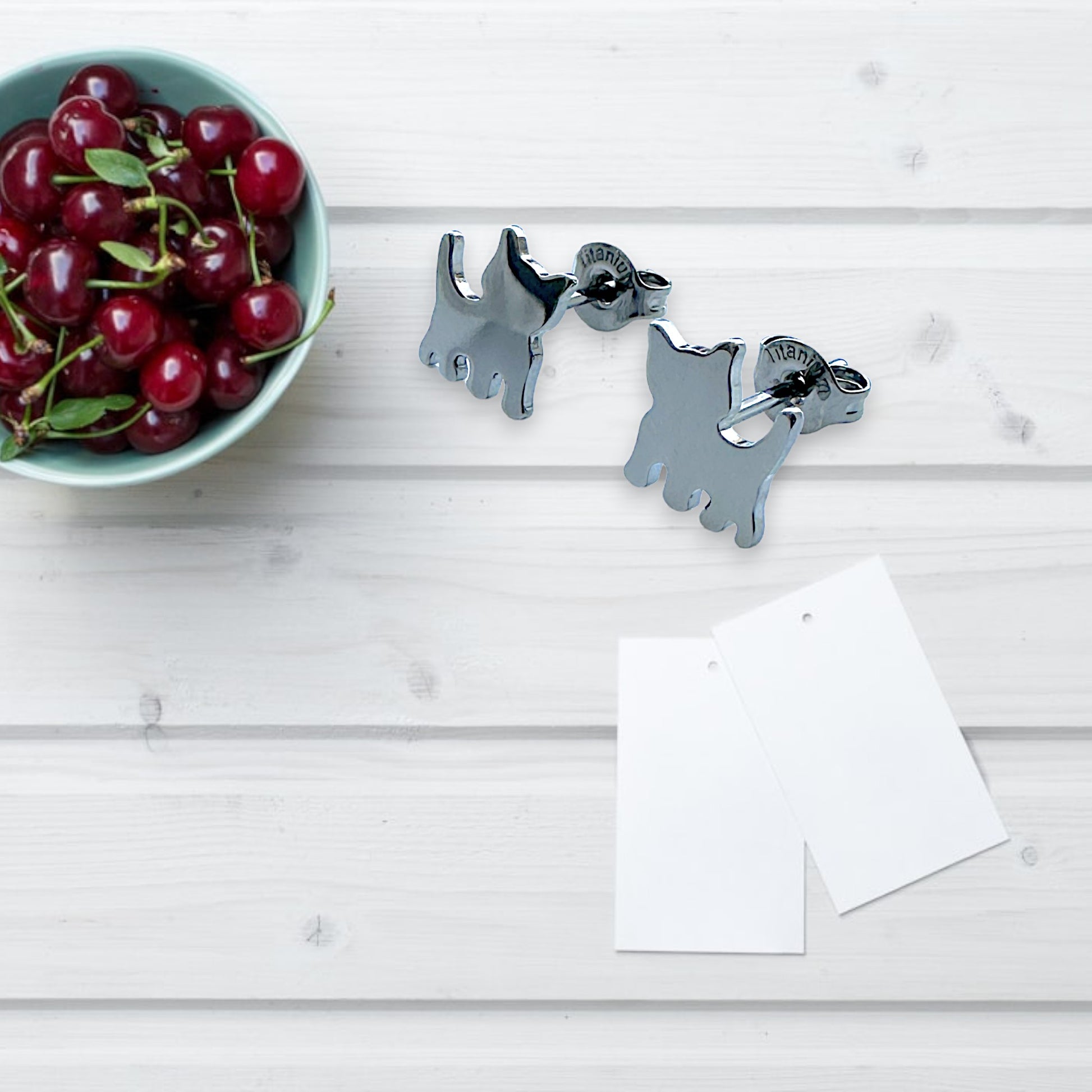 Dog studs -solid titanium studs and backs- Feature a small and minimal design on a white background with cherries