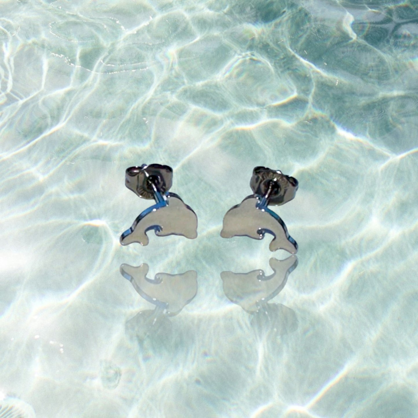 Dolphin studs -solid titanium- and studs and backs- Feature a small and minimal design on a water background