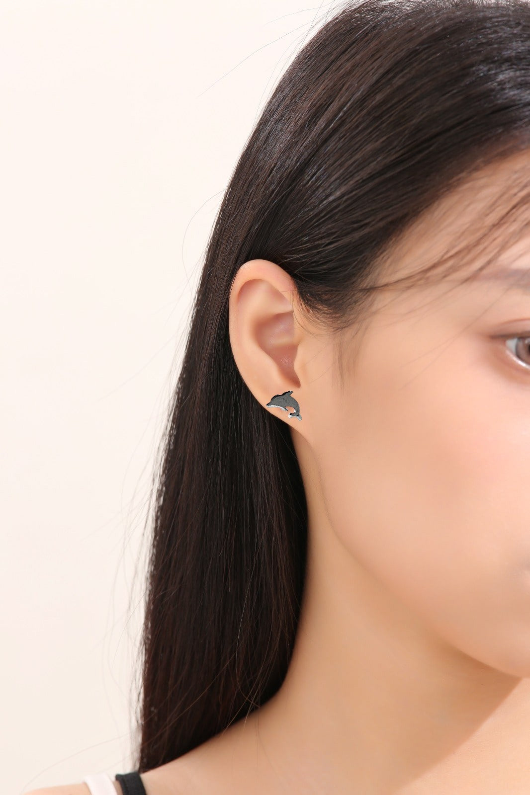 Dolphin studs -solid titanium- and studs and backs- Feature a small and minimal design on a white woman