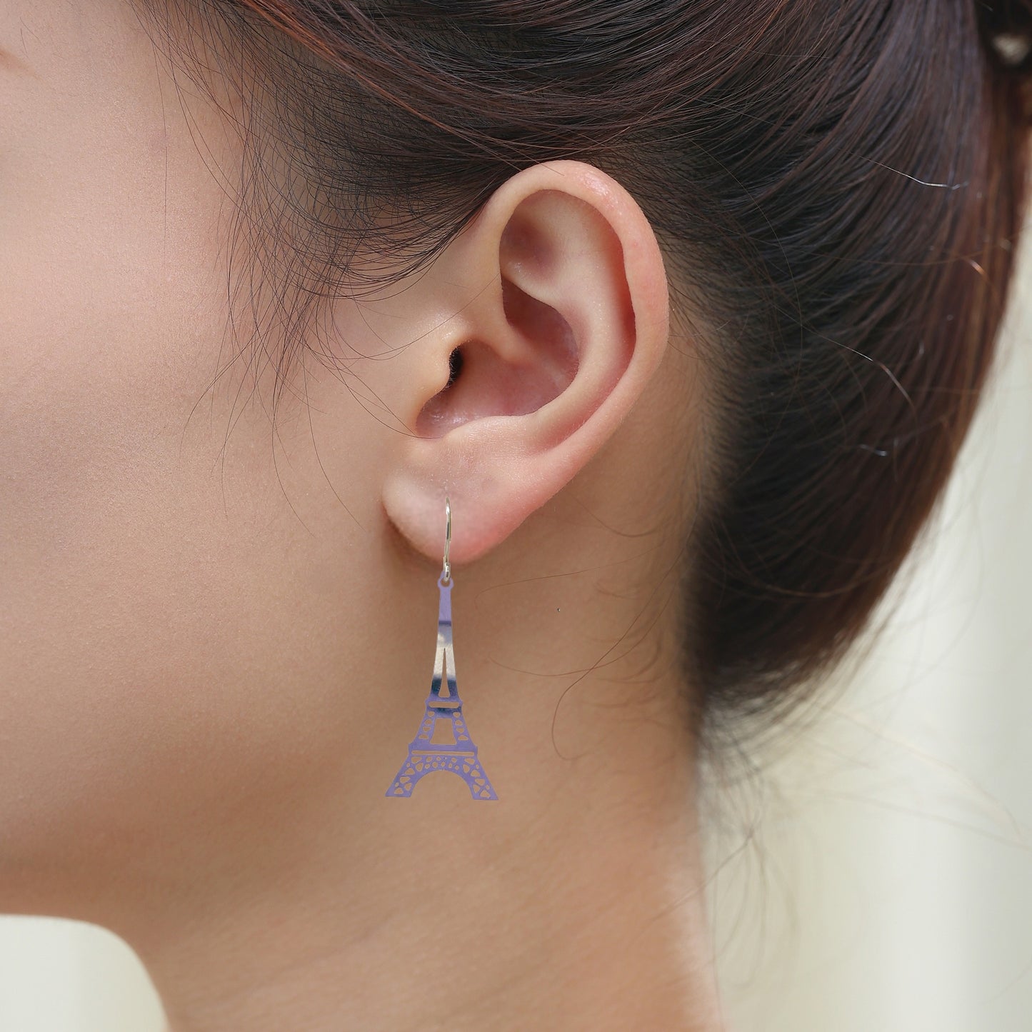 Eiffel Tower Charm earrings with a titanium hook on a white young woman