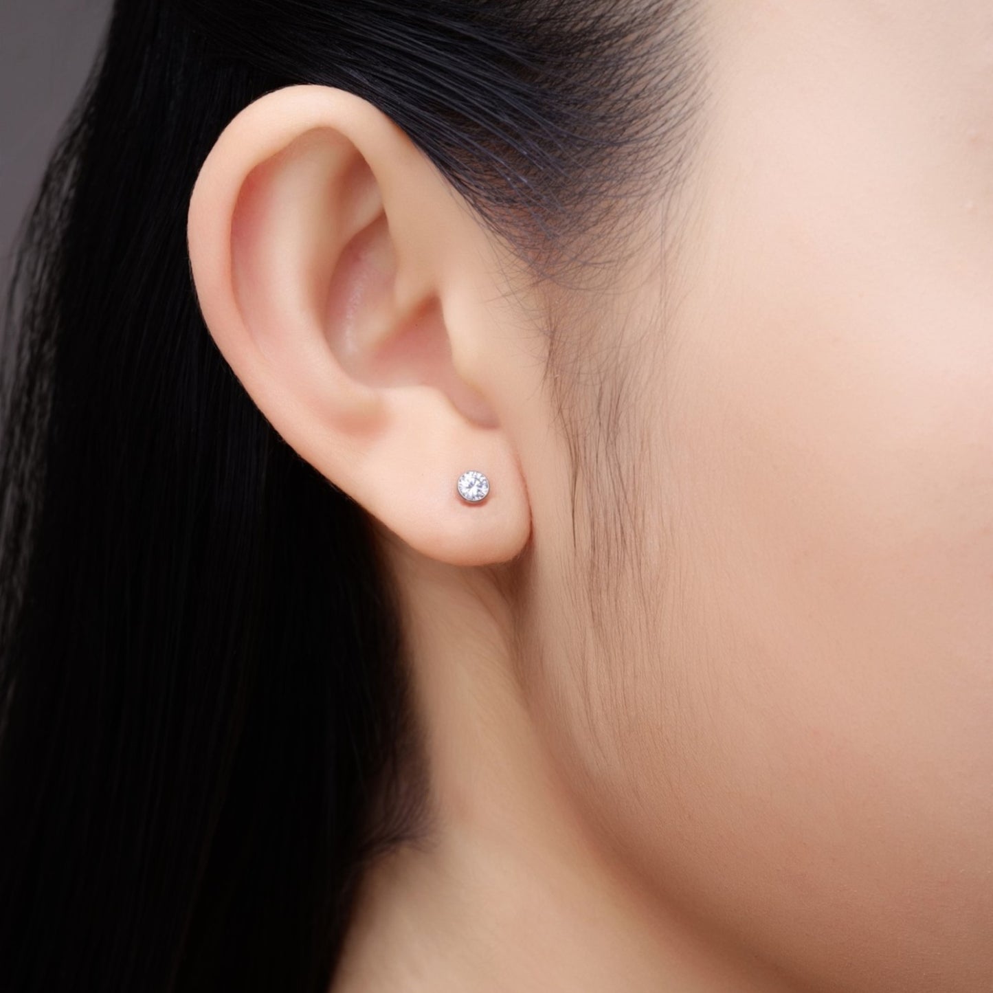 Titanium-4-mm-zirconium-flatback-stud-earrings-on-woman