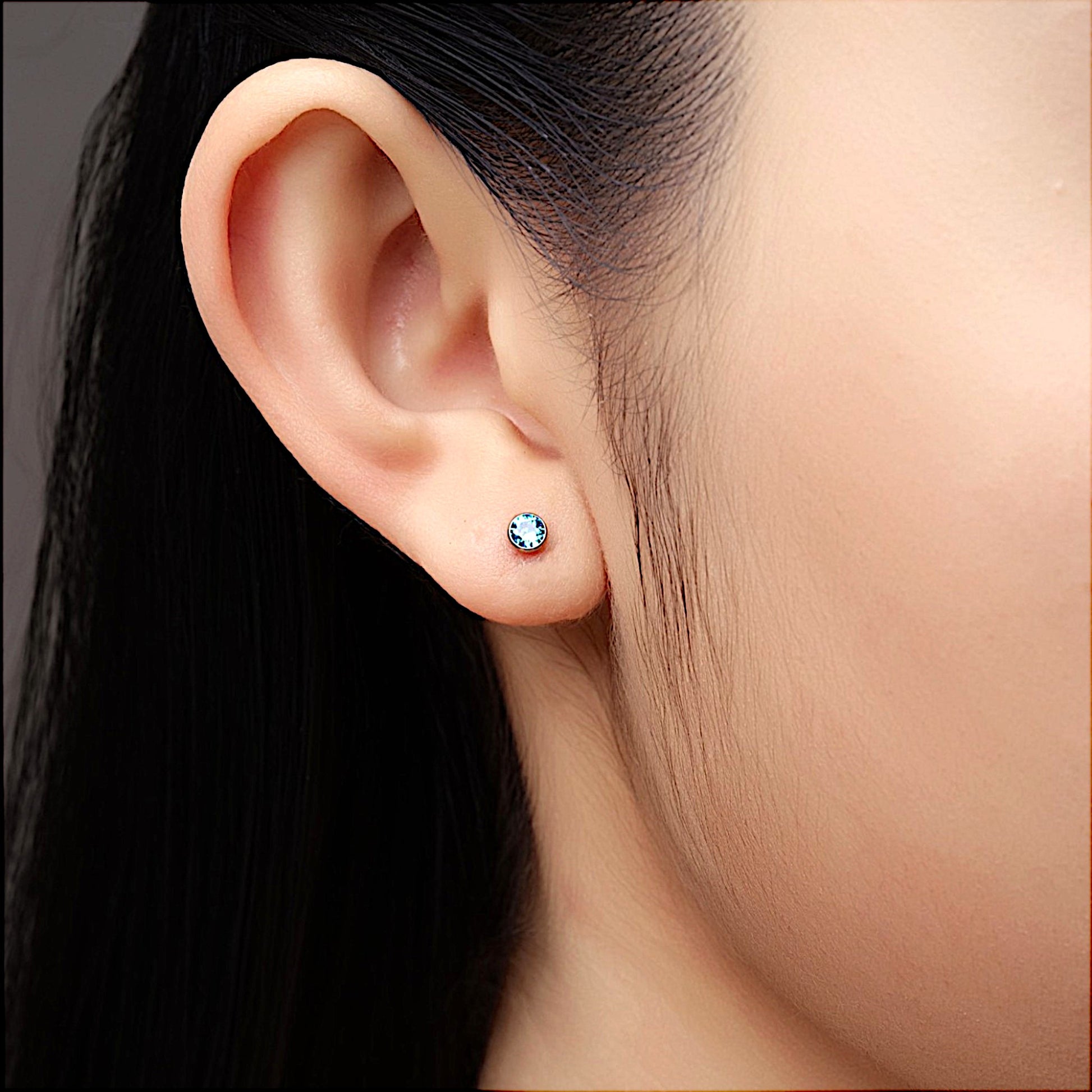 Aqua titanium 4 mm zirconium flatback  stud on a woman