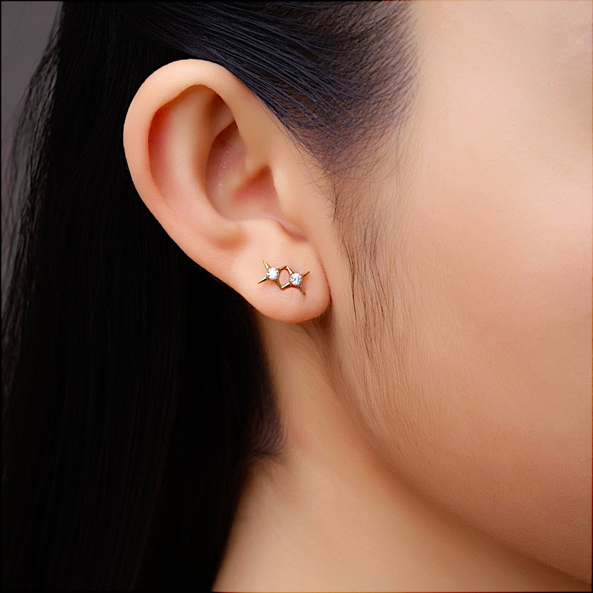 Titanium gold double star gem flat back stud on a white woman closeup