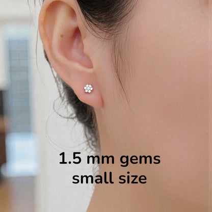 Close-up of an ear wearing a titanium flat back threadless small earring with text indicating 1.5 mm gems small size