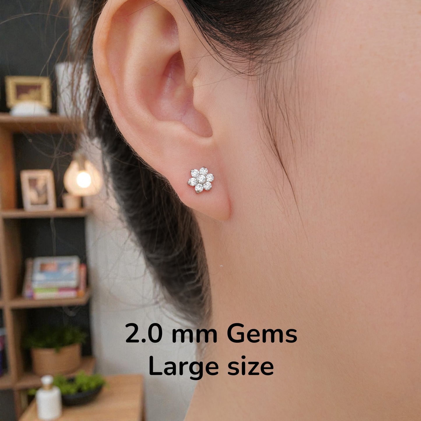 Close-up of an ear wearing a titanium flat back threadless large earring with text indicating 2.0mm gems large size