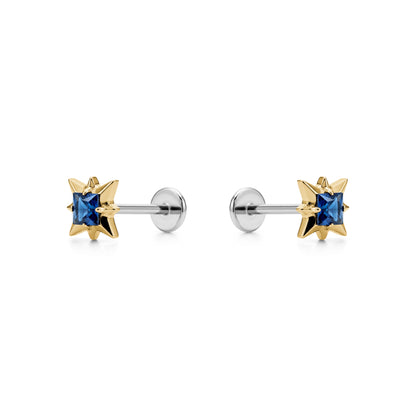 Star-shaped titanium flat back earrings with blue gemstones and gold accents on a white background