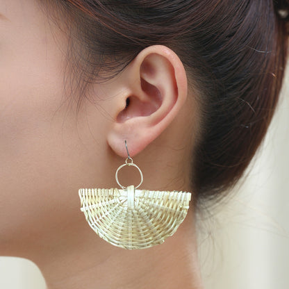 Fan bohemia style rattan earrings with a titanium hook on a black young woman