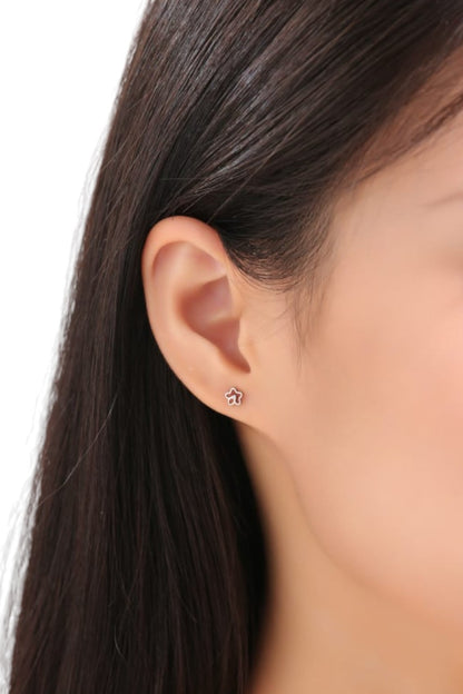 Flower stud earrings. Titanium Studs adjustable fit. These minimal studs shown on a white woman side view.