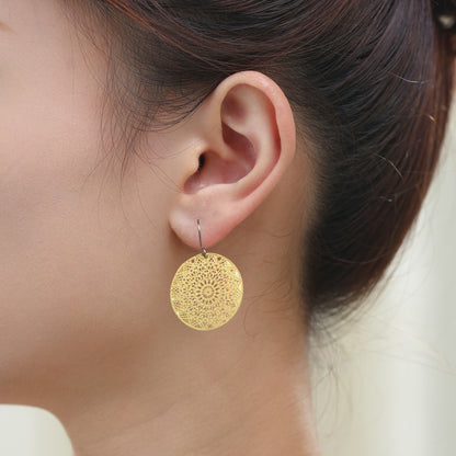 Gold Geometric disc earrings 25mm diameter with a titanium hook on a white young woman