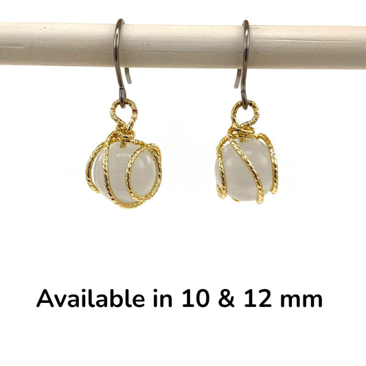 Gold caged pearl earring a titanium hook on a white backgroundearrings on a white background with text indicating size options.
