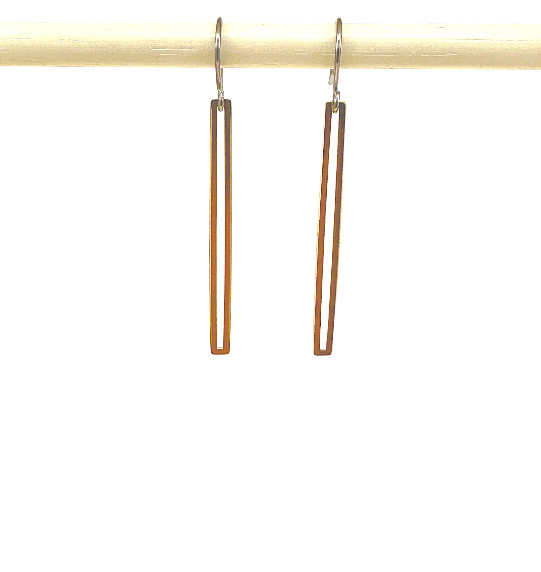 Gold narrow rectangular loop earring with a titanium hook on a white background