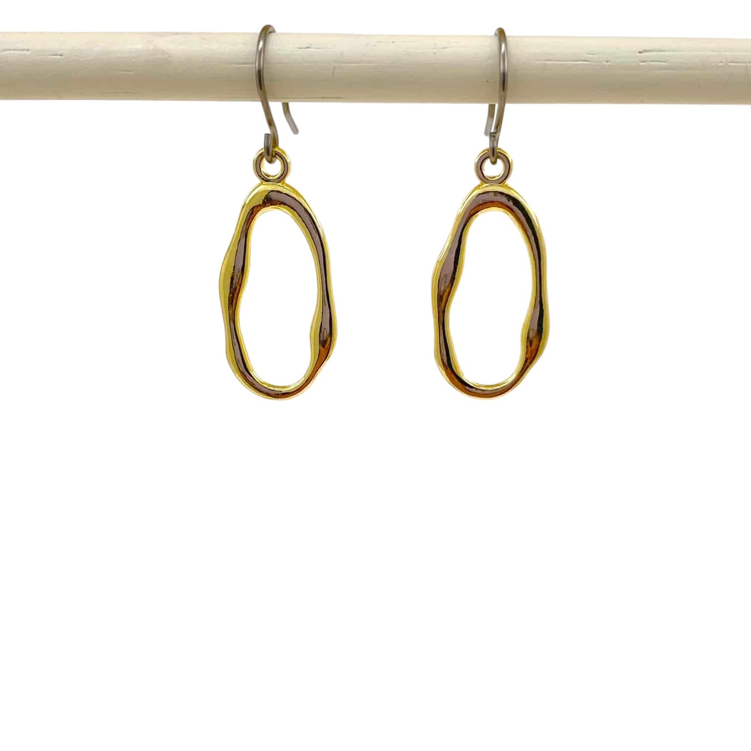 Gold oblong loop minimal earrings with a titanium hook on a white background