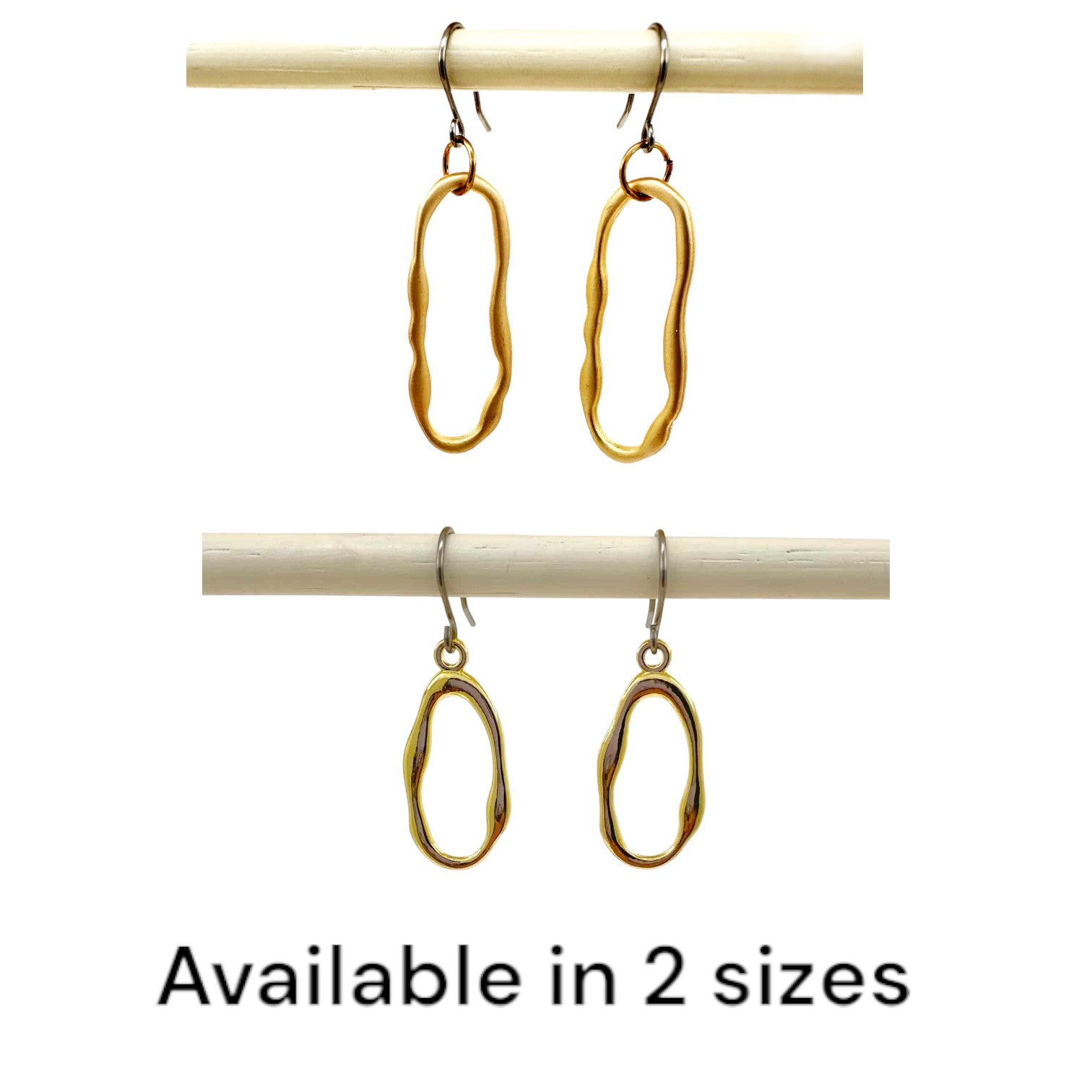 Gold oblong loop minimal earrings with a titanium hook on a white background available in 2 sizes