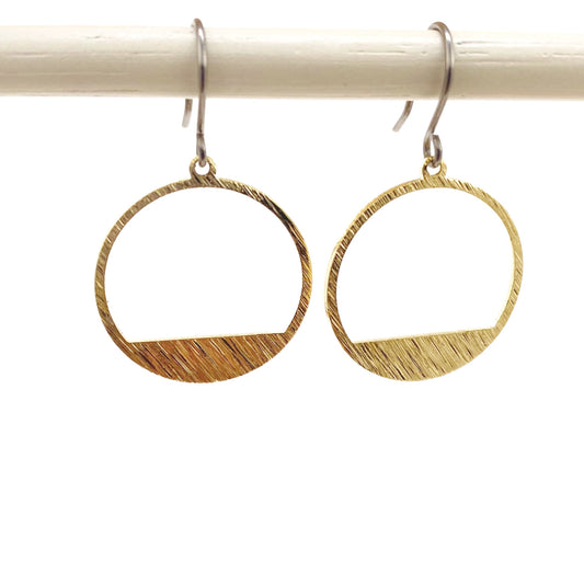 Golden rings earring with a titanium hook on a white background