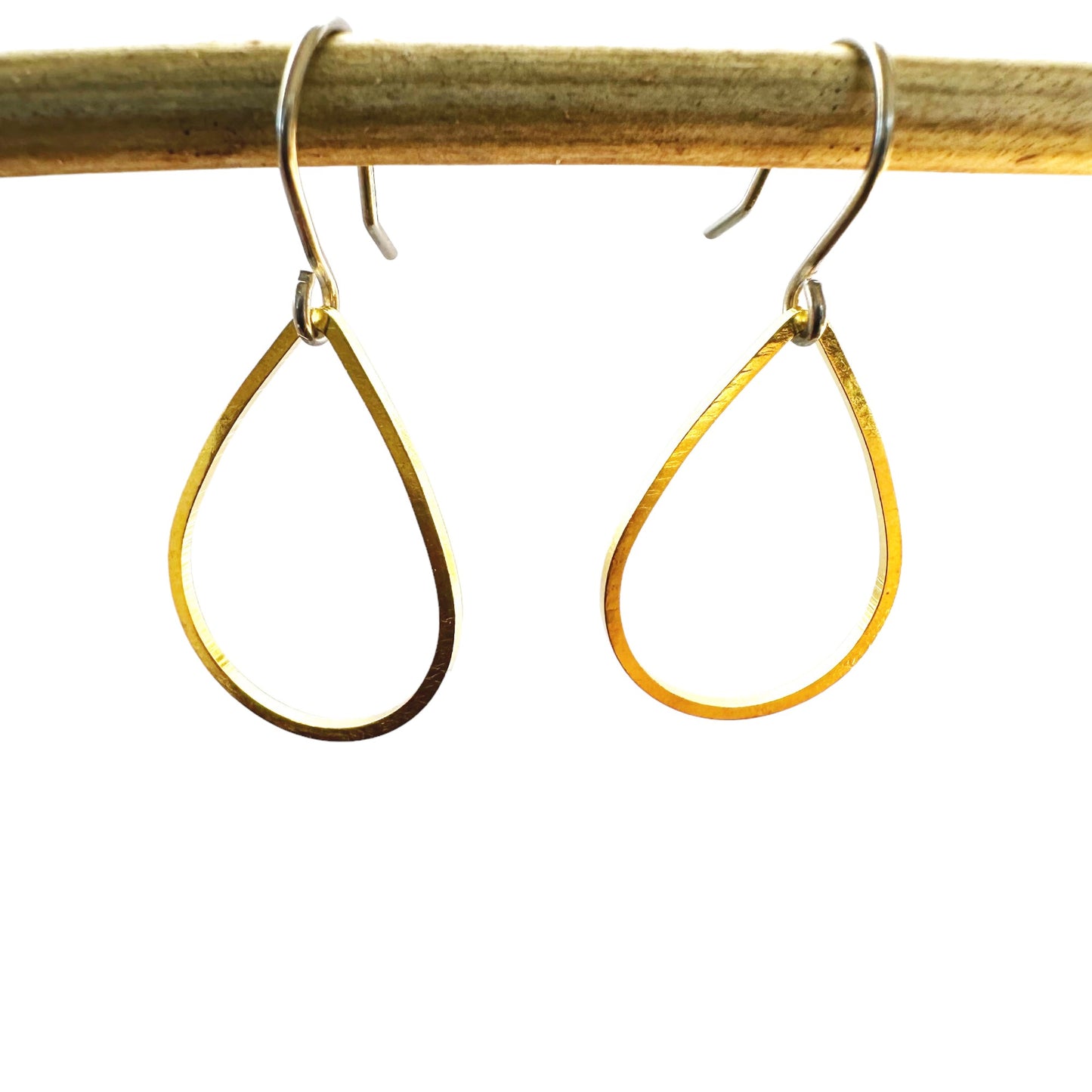 Gold minimal teardrop earring with a titanium hook on a white background