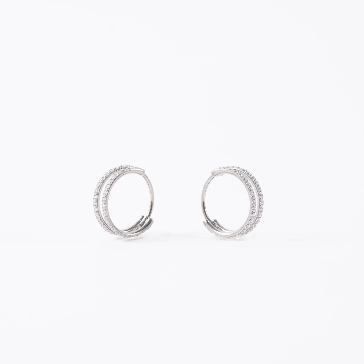 A pair of titanium double hoop earrings adorned with clear pavé-set round diamond gems, shown against a plain white background.