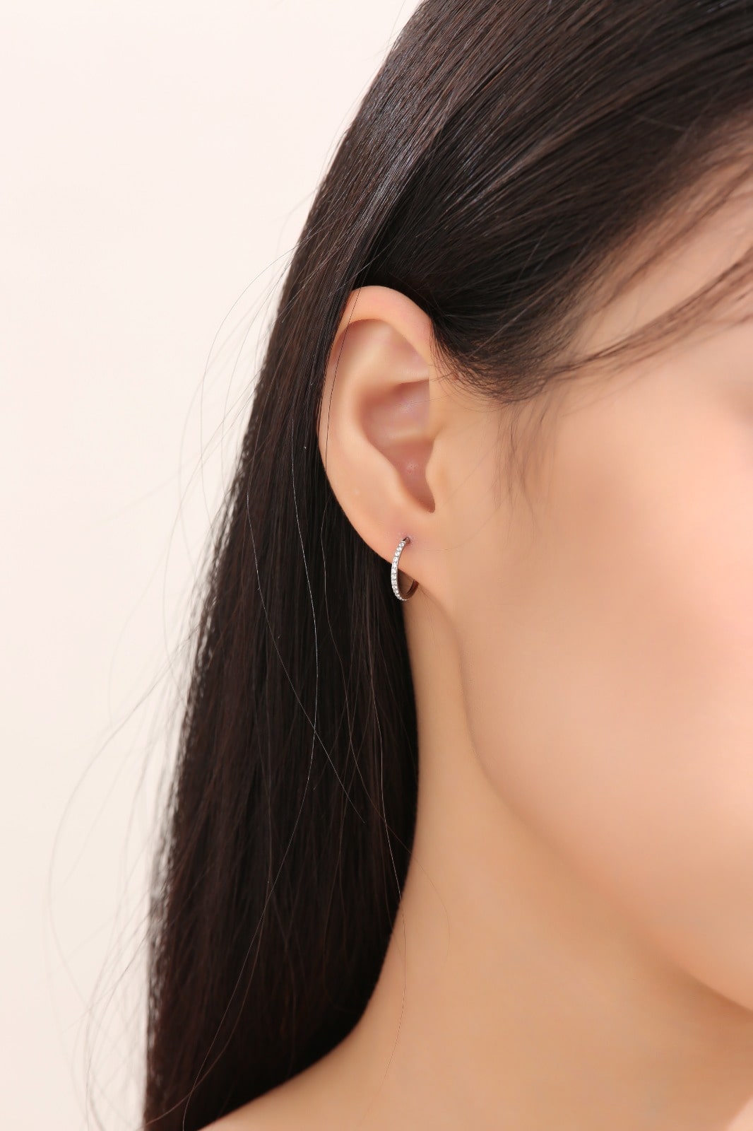 Small Hoop earrings made from titanium on a white woman gem studded earring 
