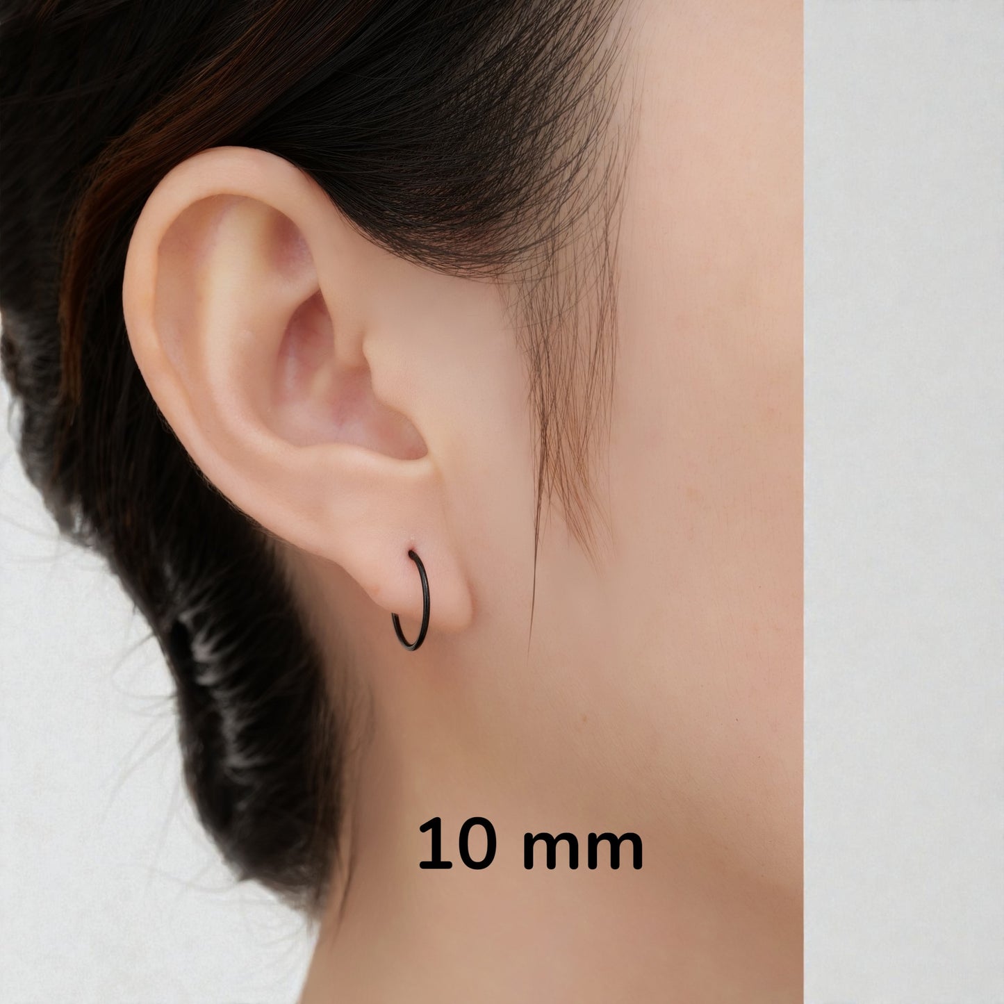 Black anodzed titanium 10 mm hoop earrings sized on a woman