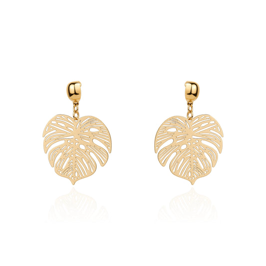 A pair of gold interchangeable drop earrings featuring openwork monstera leaf designs, displayed on a clean white background with a soft reflection below.