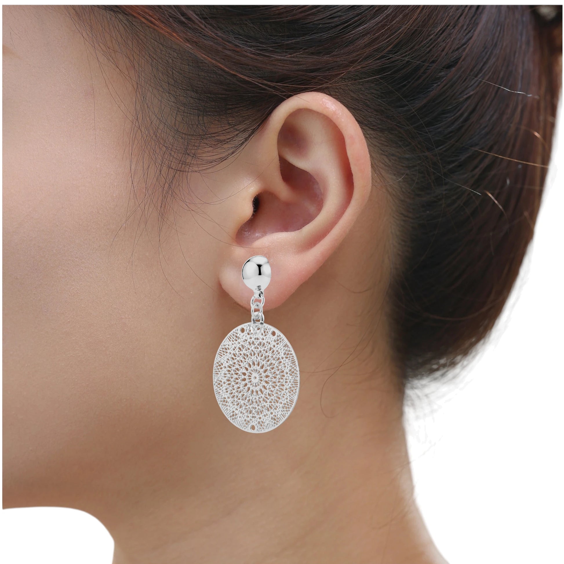 Titanium interchangeable magnetic silver disc earrings with intricate designs on a woman