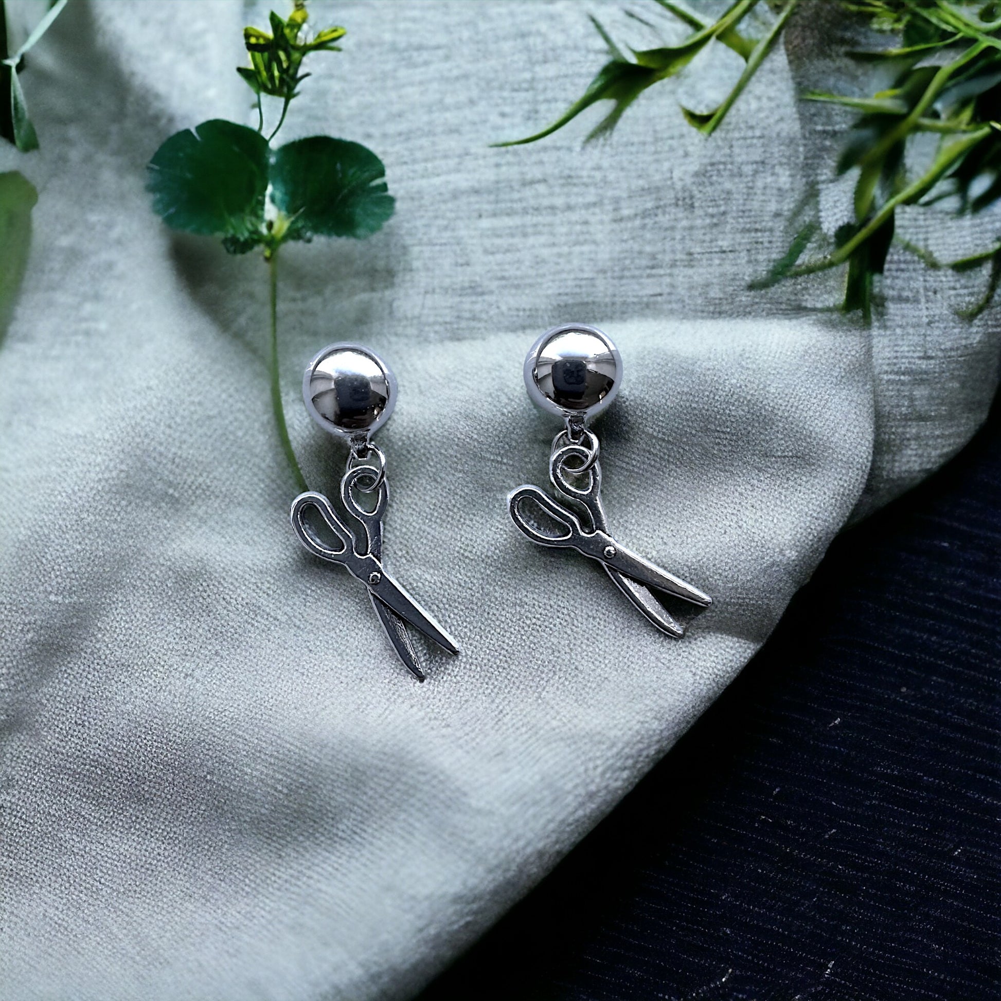 Interchangeable Mini scissor earrings. Detachable earrings for a truly hypoallergenic jewellery on a white and green background