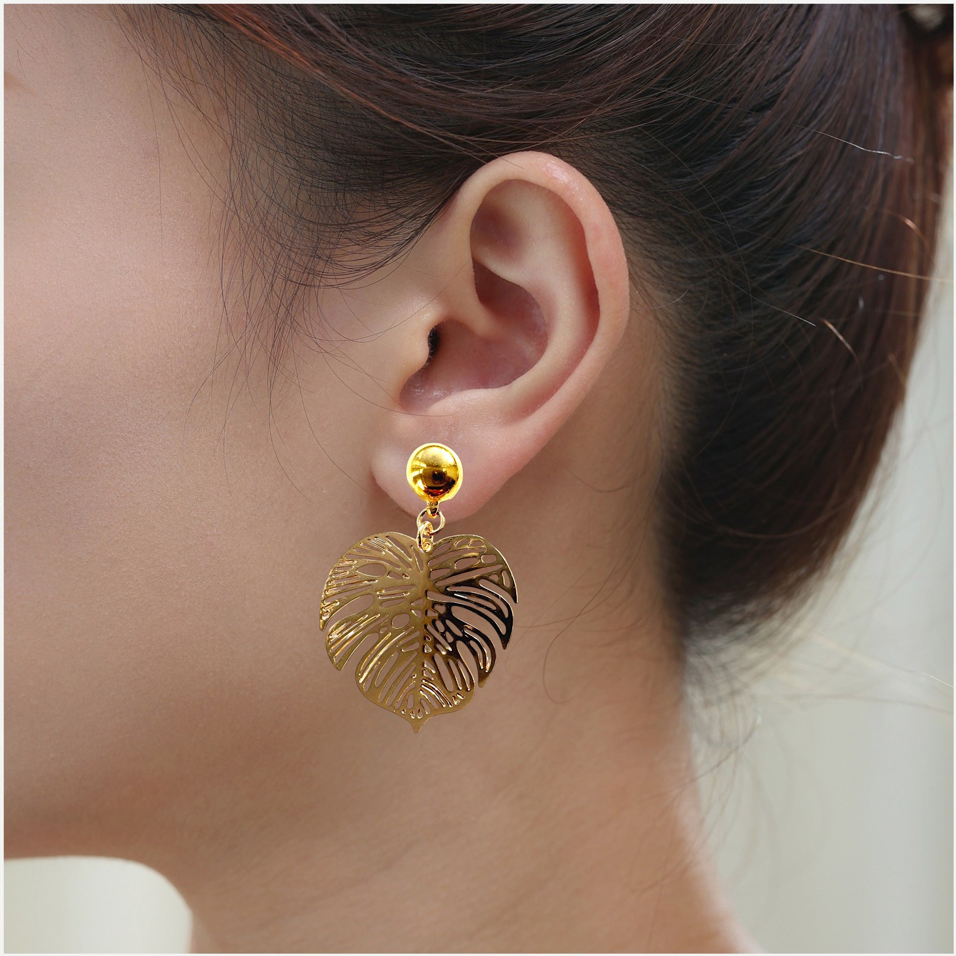 Large Monstera Leaf Earrings. Detachable earrings for a truly hypoallergenic jewellery on a white young woman