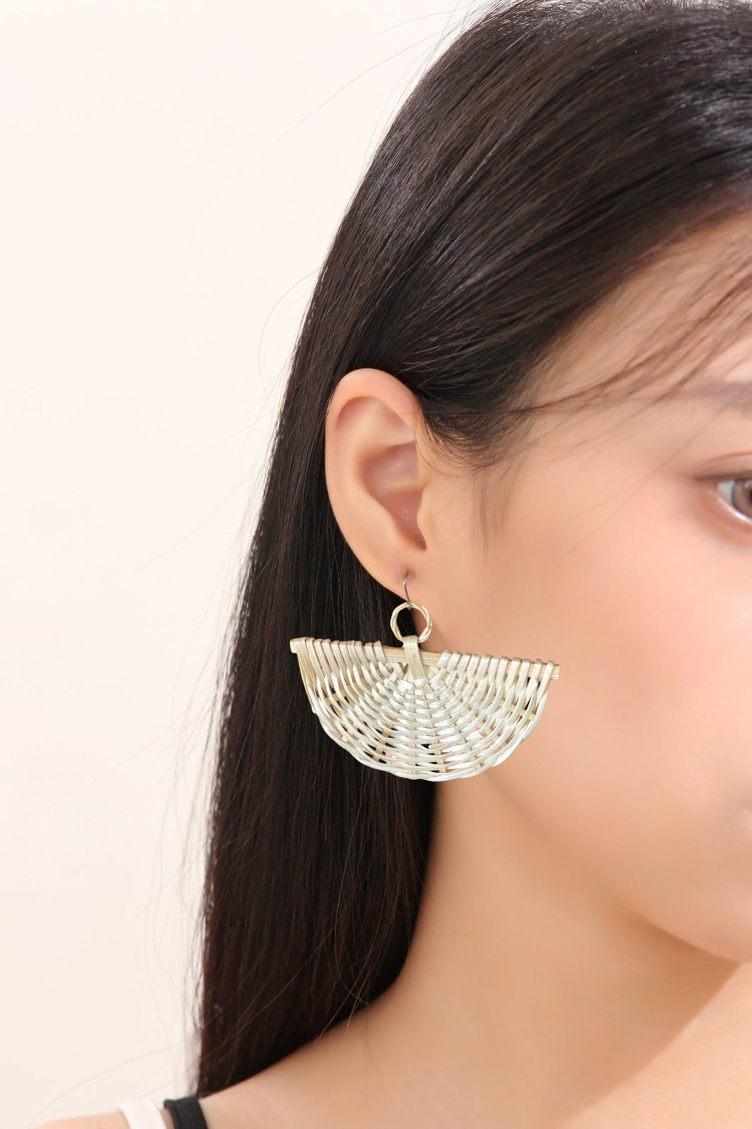 Large Fan bohemia style rattan earrings with a titanium hook on a white young woma