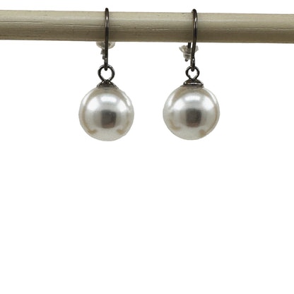 Large pearl earrings with a titanium hook on a white background