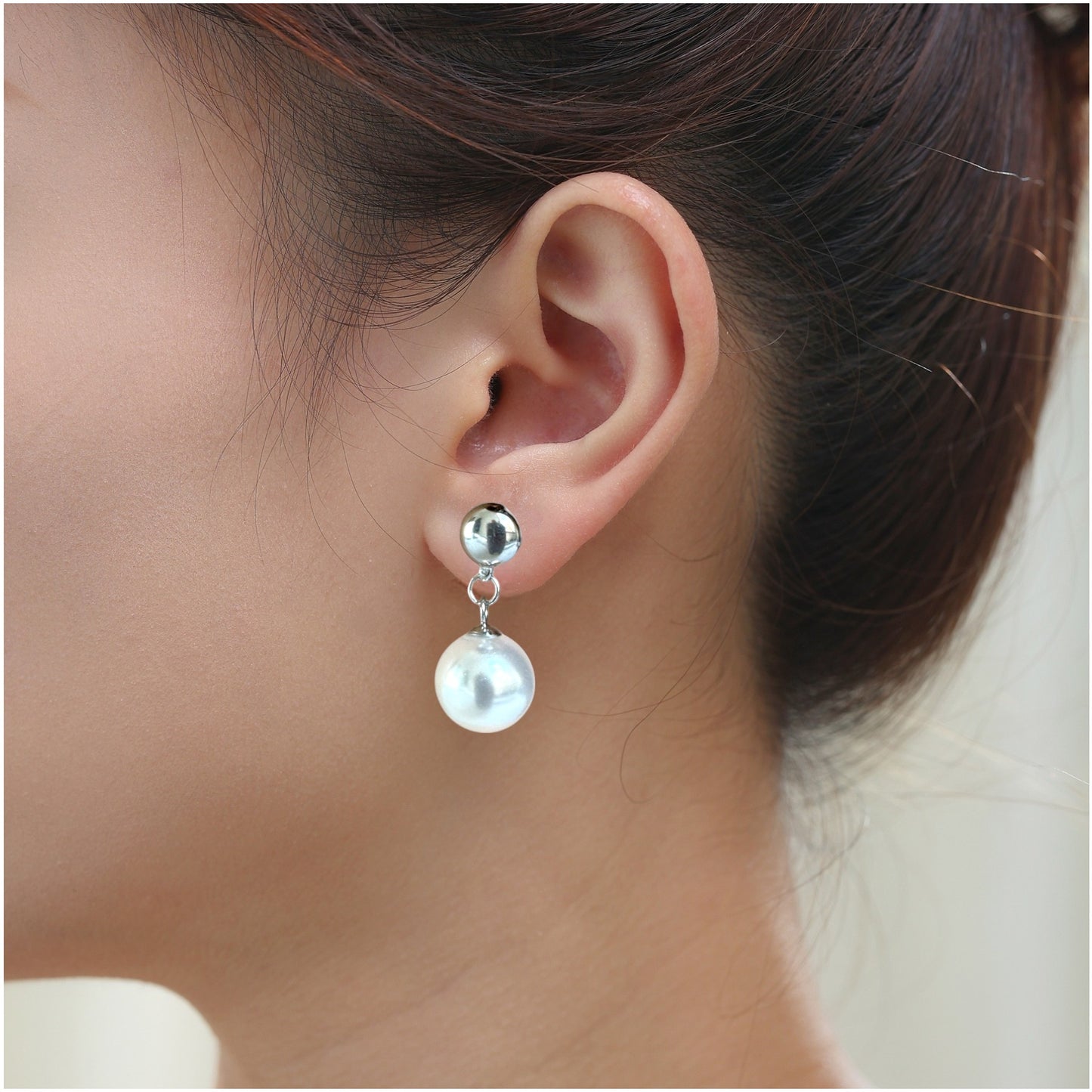 Large pearl earrings. Detachable earrings for a truly hypoallergenic jewellery on a white young woman