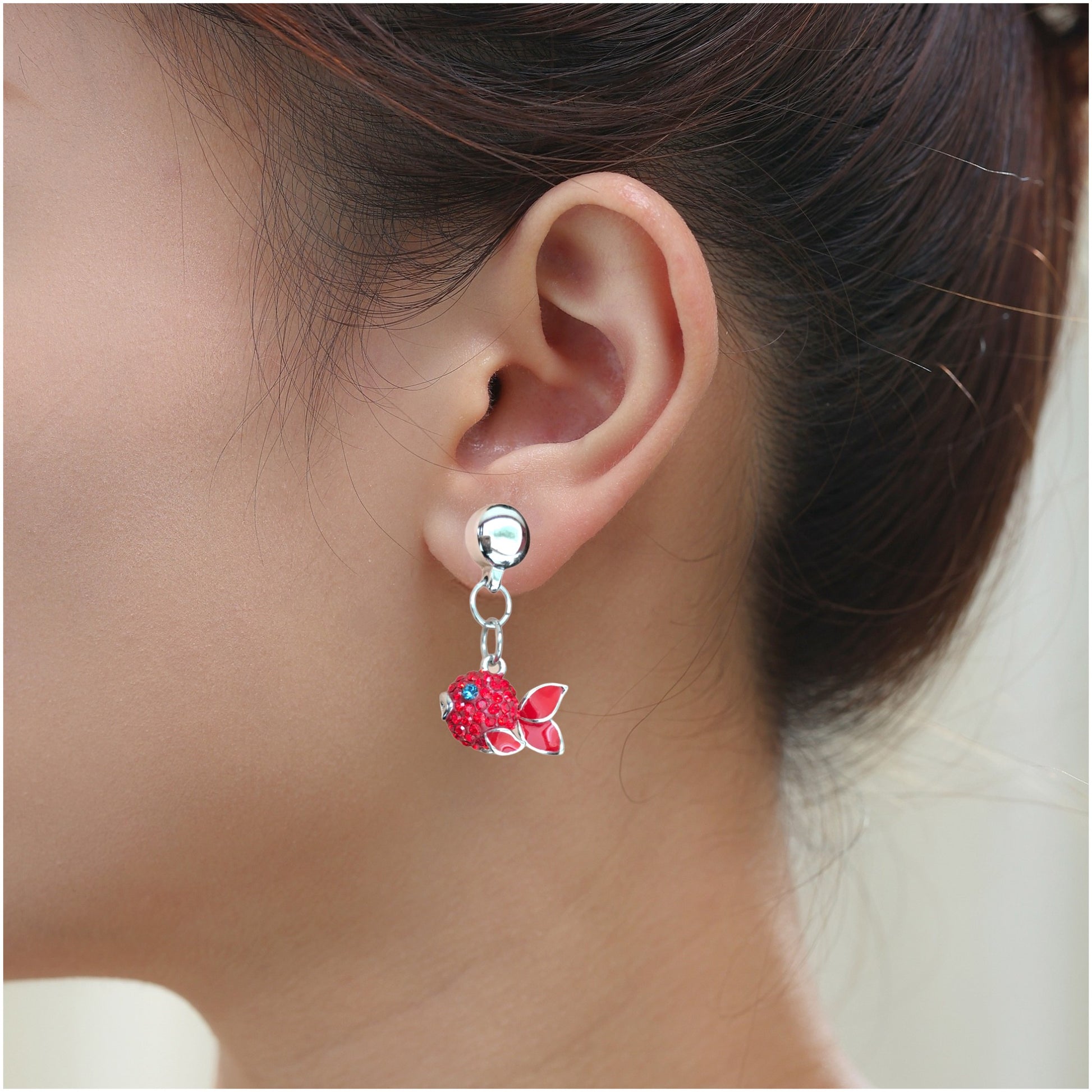 Fish Charm earrings. Magnetic titanium interchangeable earring system. Detachable earrings for a truly hypoallergenic jewellery on a white young woman. red