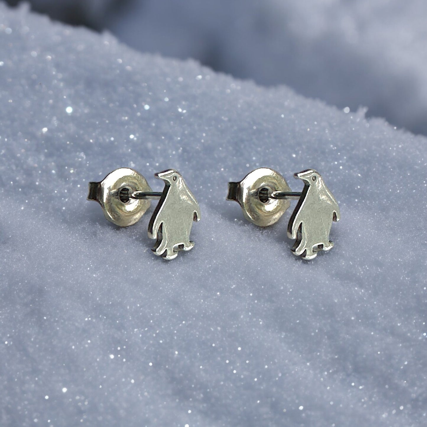 Penguin studs -solid titanium studs and backs- Feature a small and minimal design on a snow background